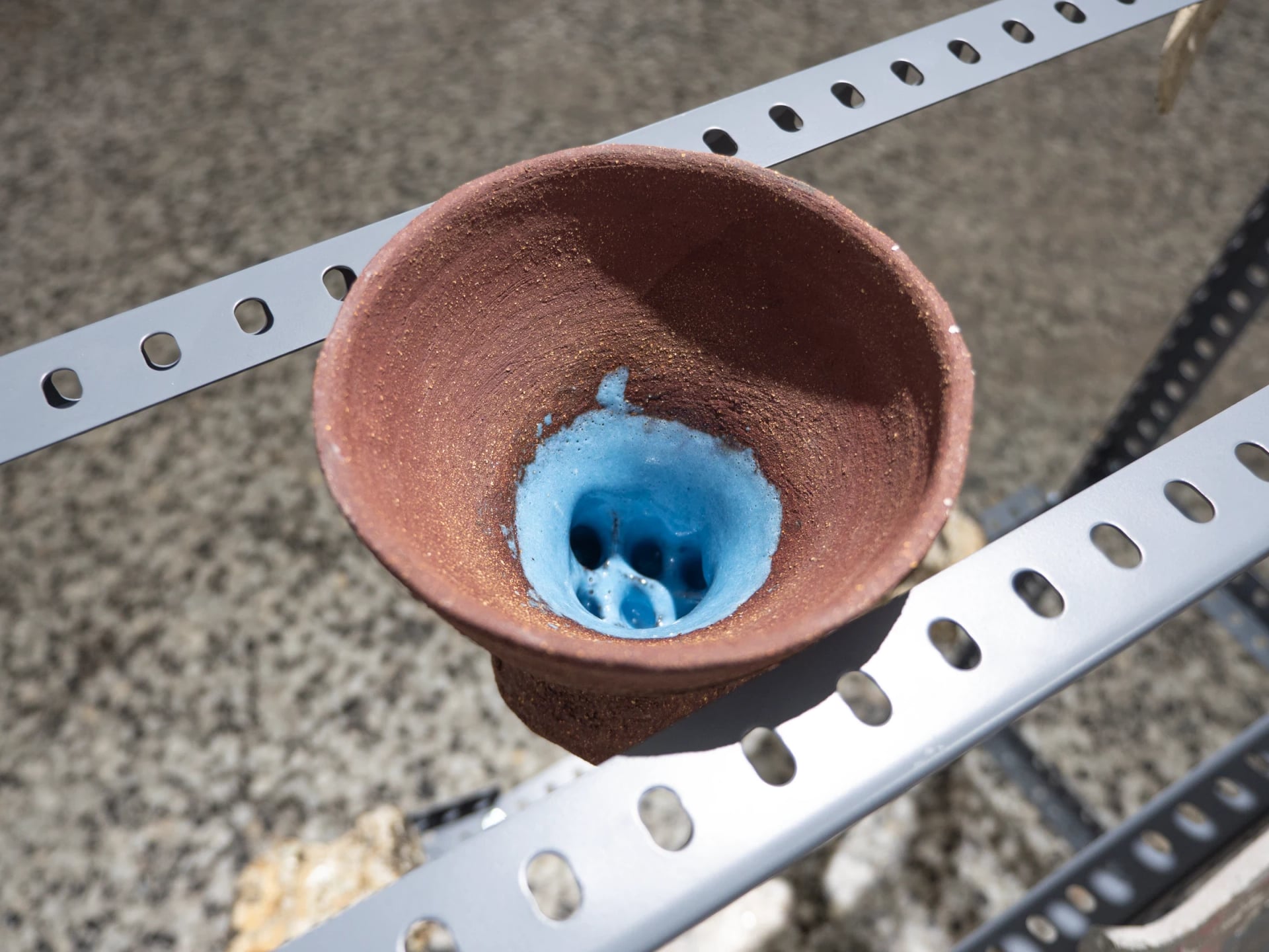 Detalle cerámico con esmalte azul sobre estructura metálica